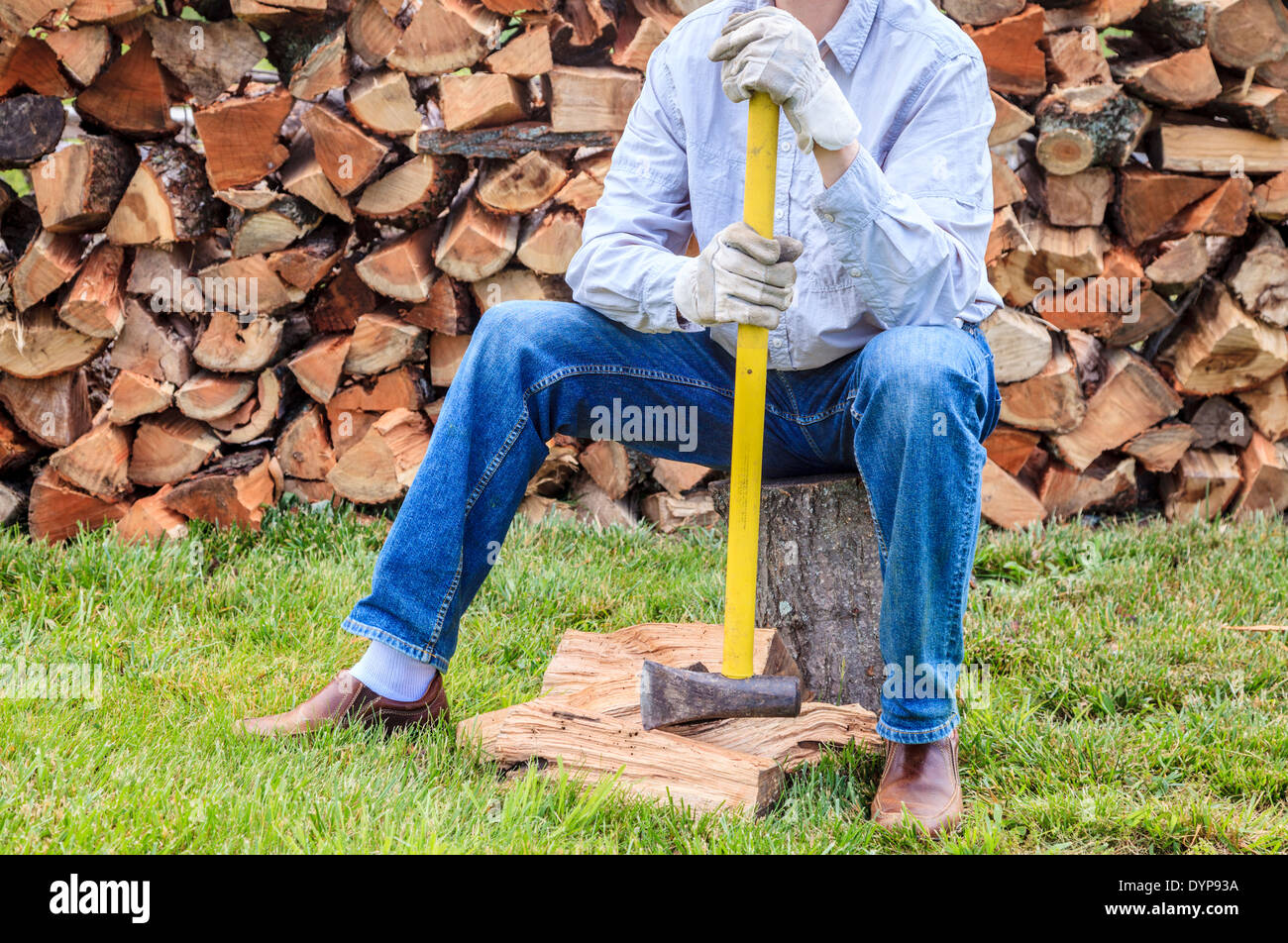 El hombre está tomando un descanso de rajar leña Foto de stock