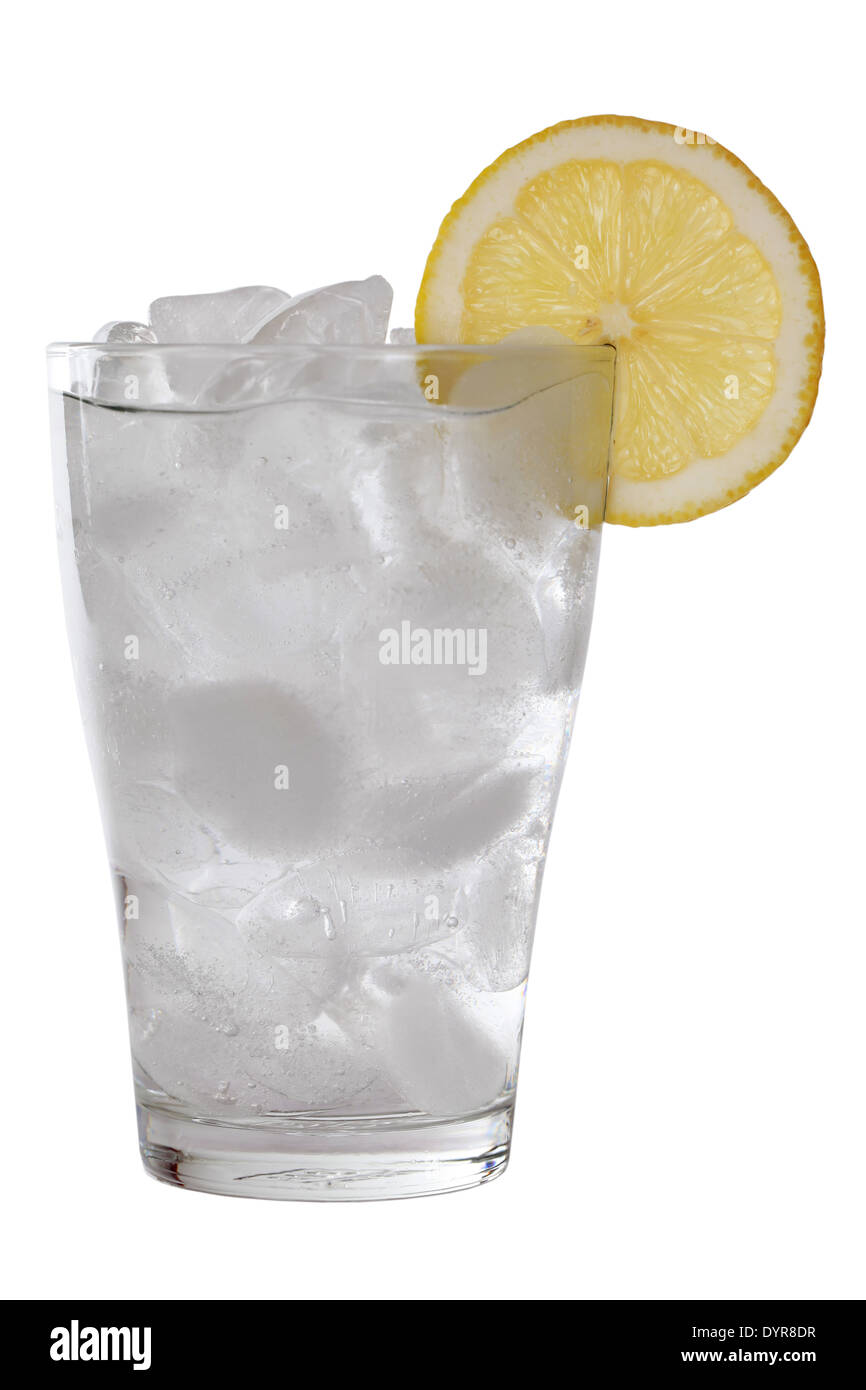 En un vaso de agua fría con cubitos de hielo, servido con un limón, aislado en blanco Foto de stock
