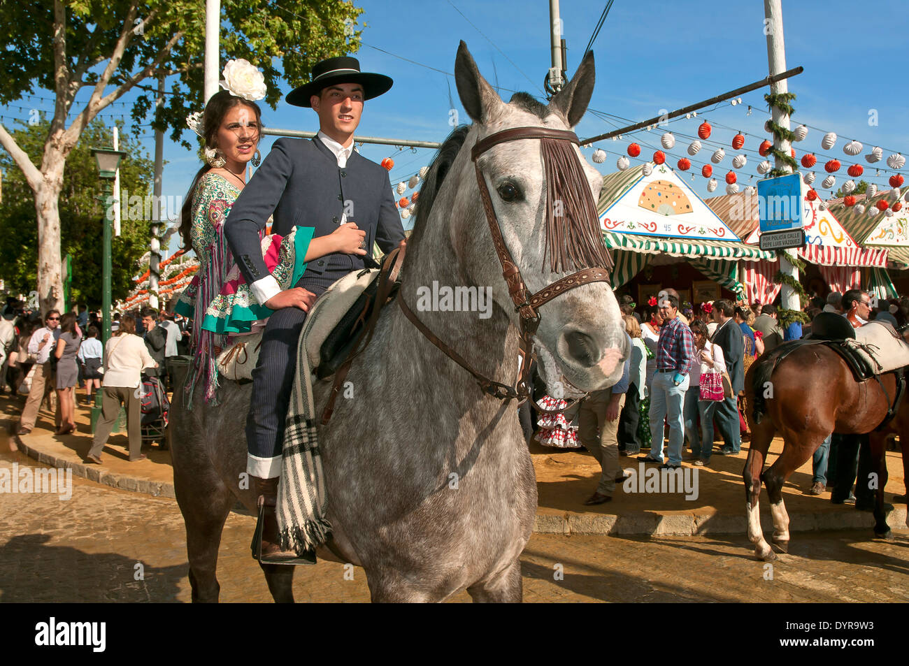 Feria de Abril, pareja joven montando a caballo, en Sevilla, en la región de Andalucía, España, Europa Foto de stock