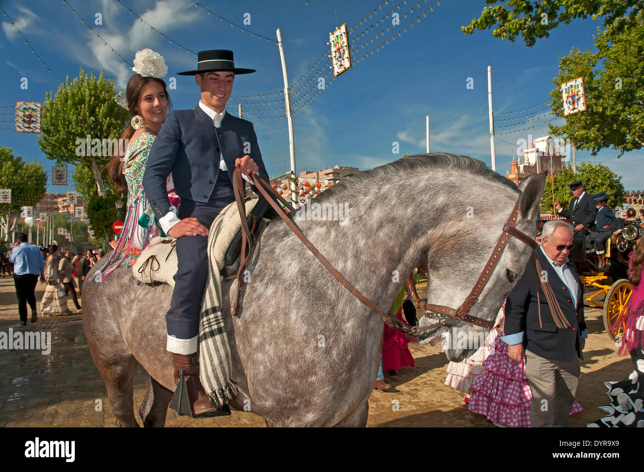 Feria de Abril, pareja joven montando a caballo, en Sevilla, en la región de Andalucía, España, Europa Foto de stock