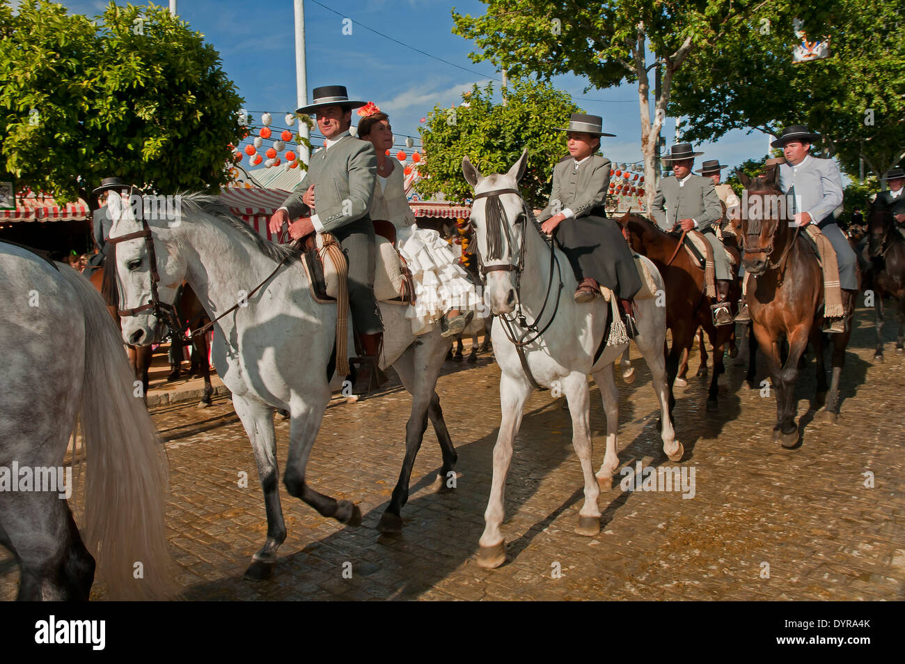 Feria de Abril, jinetes montando a caballo con los tradicionales trajes de flamenca, Sevilla. Región de Andalucía, España, Europa Foto de stock