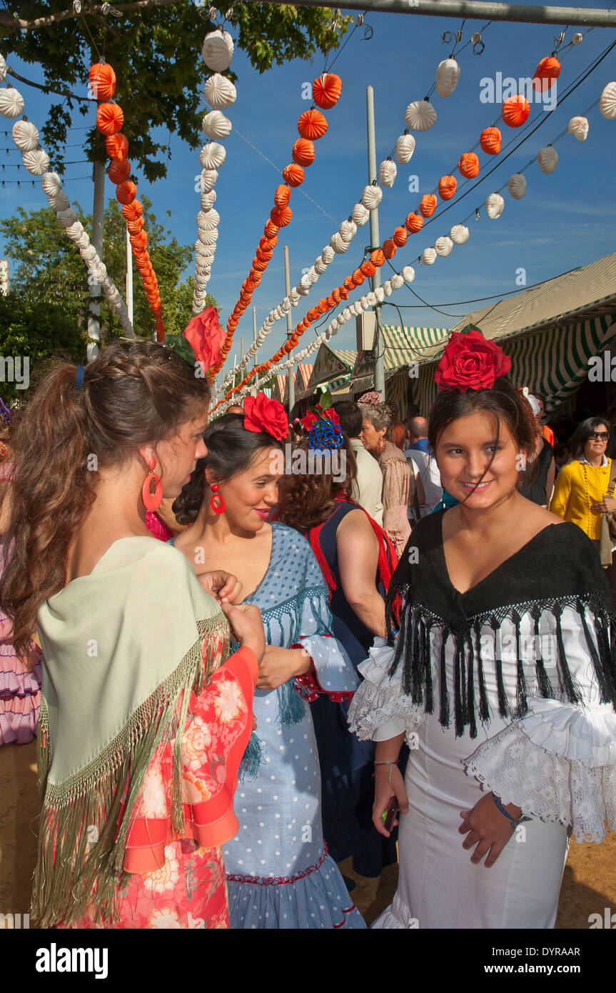Feria de Abril, las mujeres jóvenes vistiendo un traje flamenco tradicional, Sevilla, en la región de Andalucía, España, Europa Foto de stock