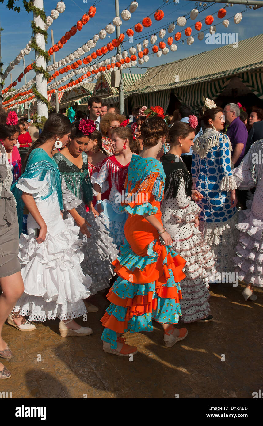 Feria de Abril, las mujeres jóvenes vistiendo un traje flamenco tradicional, Sevilla, en la región de Andalucía, España, Europa Foto de stock