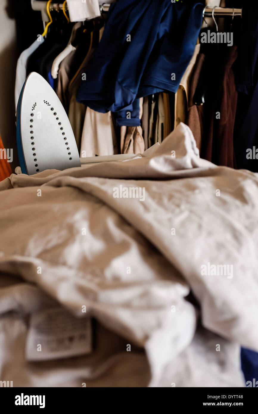 Un montón de ropa para planchar con una plancha eléctrica visible entre las  sábanas Fotografía de stock - Alamy