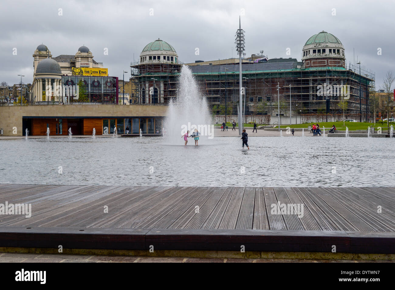 Bradford - 3 tres niños que jugaban en la Plaza Centenario Lago Bretaña UK en frente del teatro Alhambra y antiguo Teatro Odeon Foto de stock