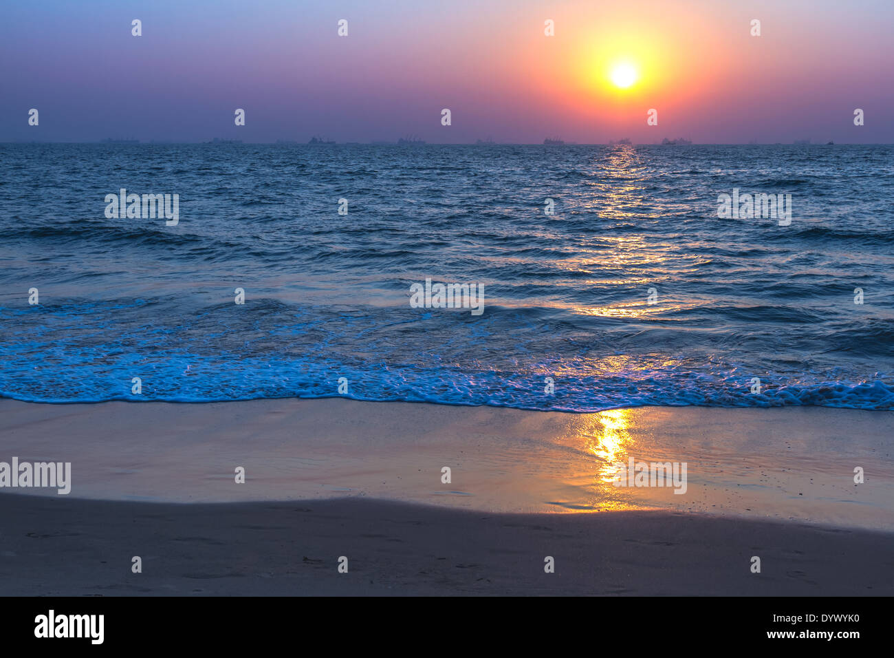 Vista panorámica de la playa de arena de Goa a la hermosa puesta de sol sobre el mar Arábigo. Reflejo del sol sobre la superficie del mar Foto de stock