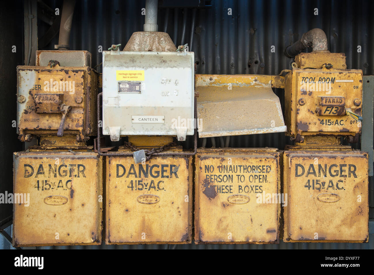 Una serie de amarillo de acero oxidado cajas de alimentación fuera una fábrica Foto de stock