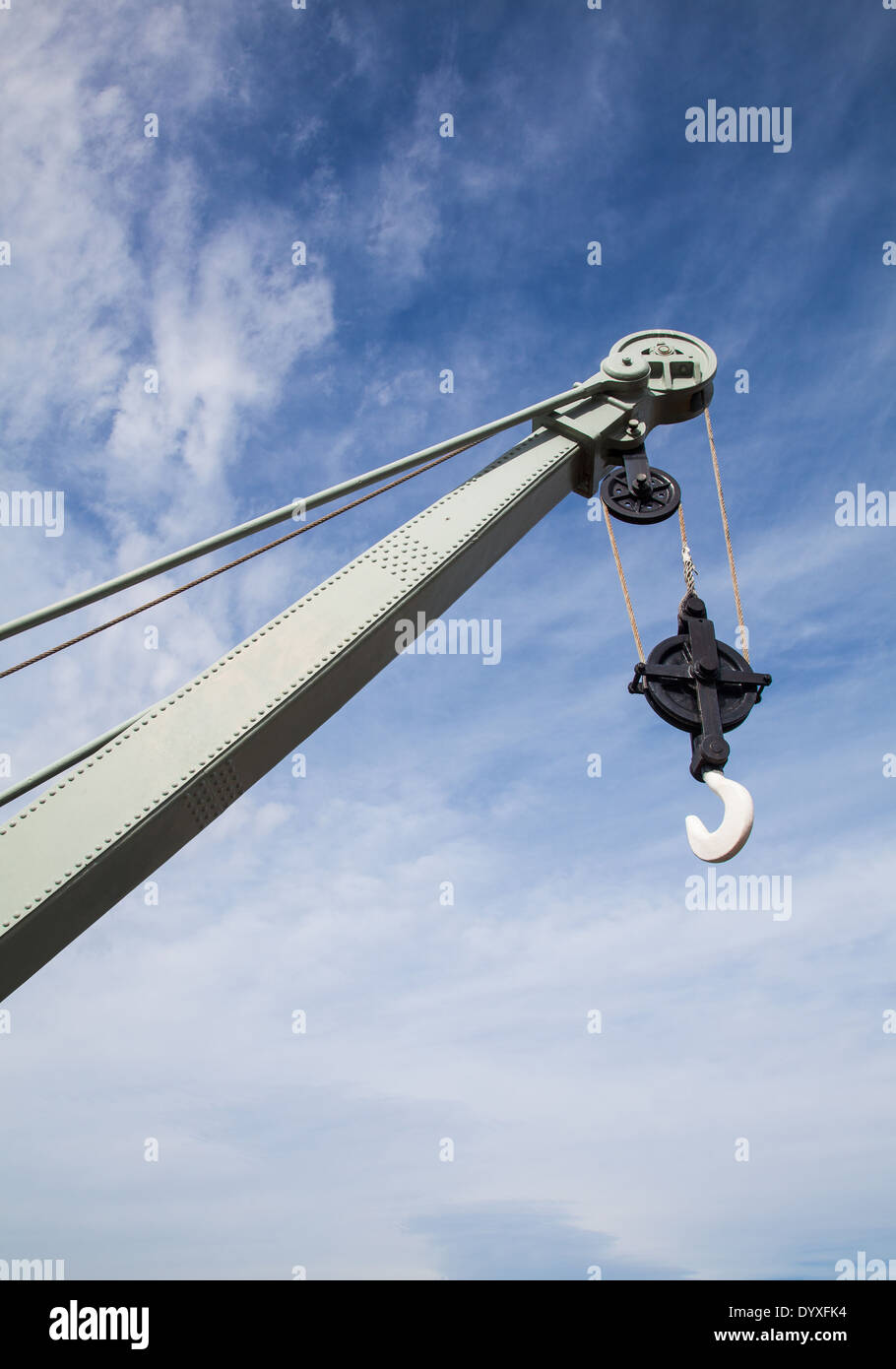 El extremo del gancho de una grúa vieja contra un cielo azul Foto de stock