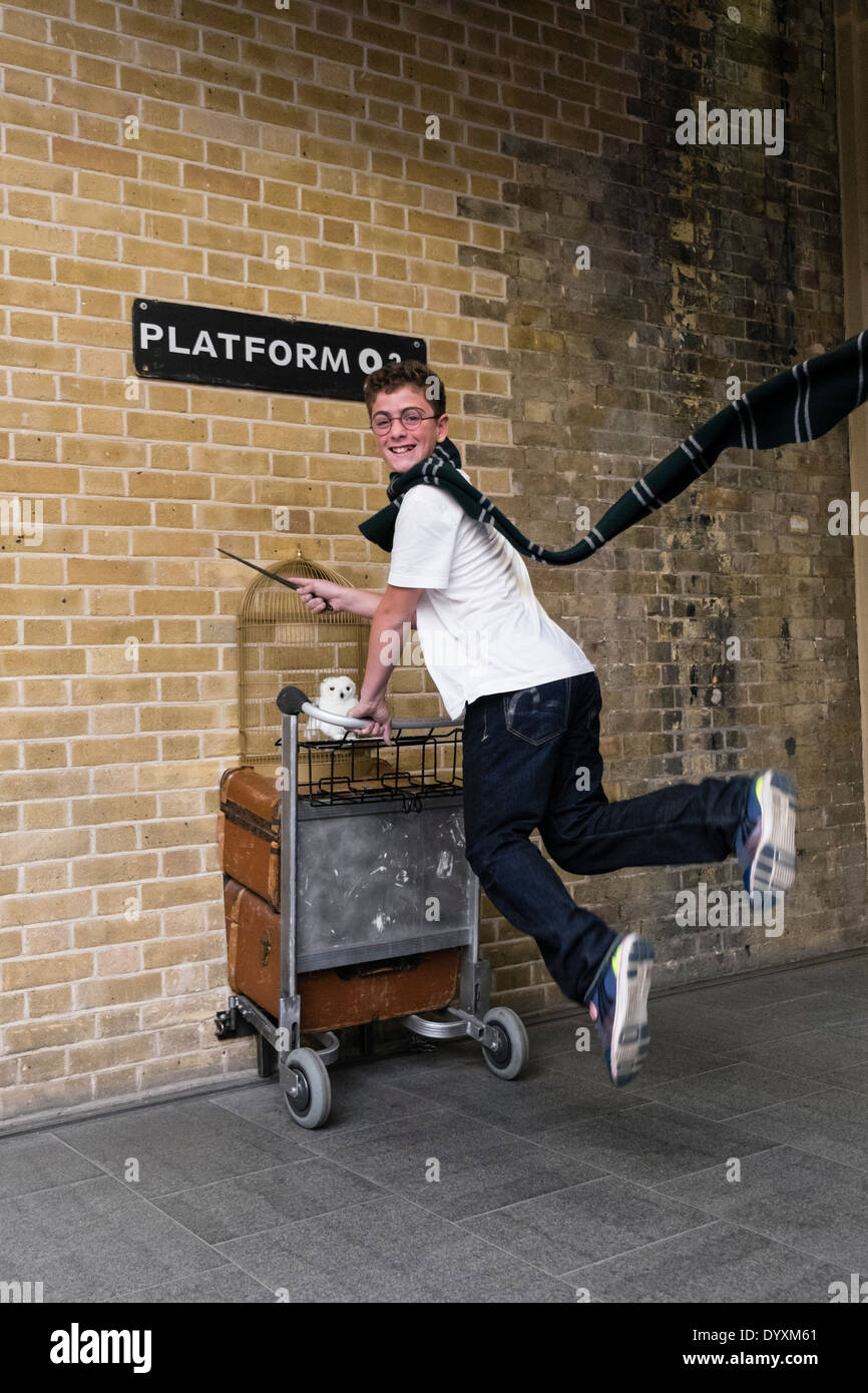 Harry Potter fan saltando a la plataforma 9 3/4 en la estación de King's Cross en Londres, Reino Unido Foto de stock