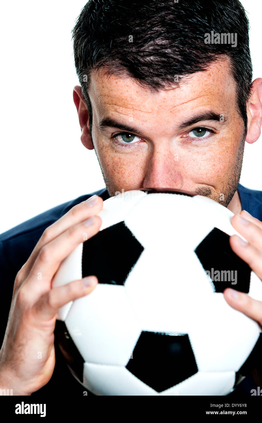 Primer plano de apasionado jugador de fútbol con balón blanco y negro Foto de stock
