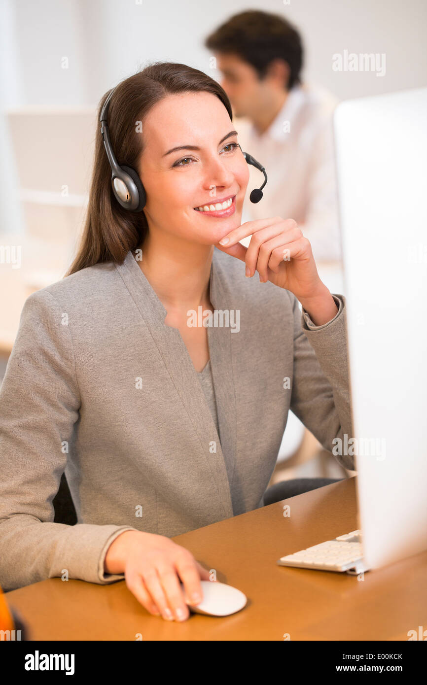 Mujer sonriente escritorio bonito retrato de auriculares Foto de stock