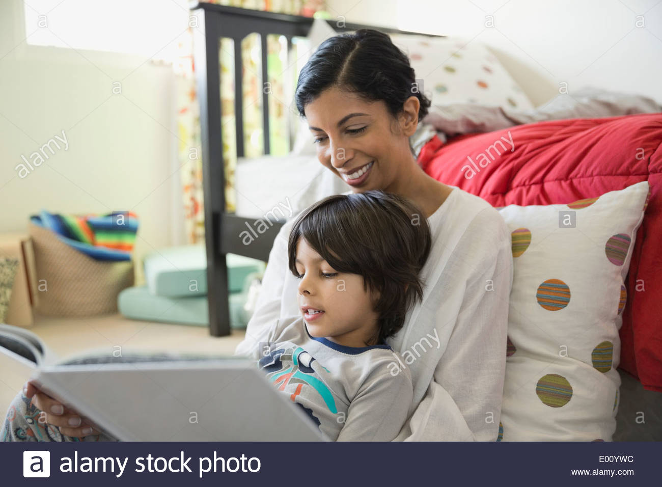 Madre e hijo libro de lectura en el dormitorio Foto de stock