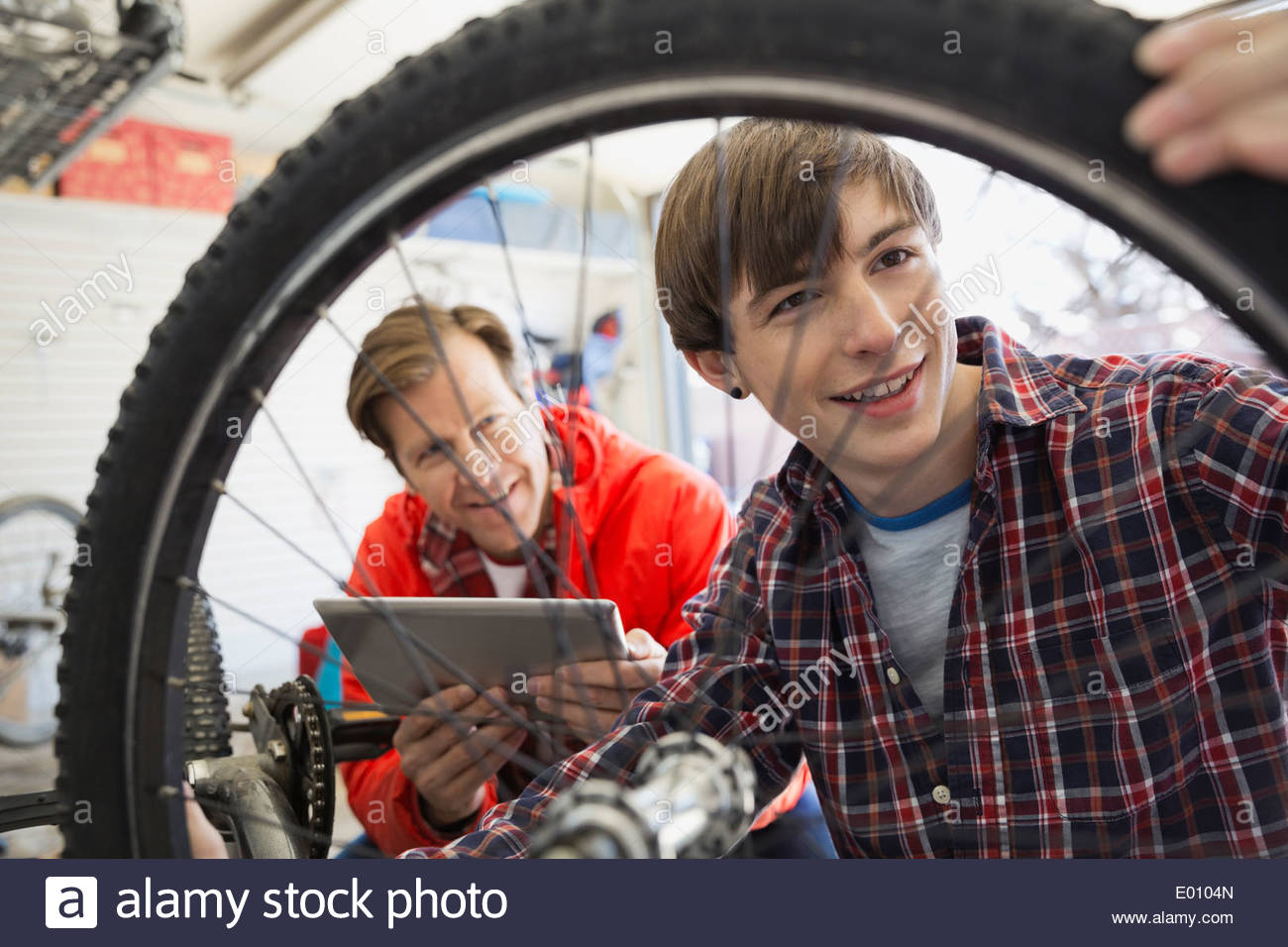 Padre e hijo reparando bicicletas en el garaje Foto de stock
