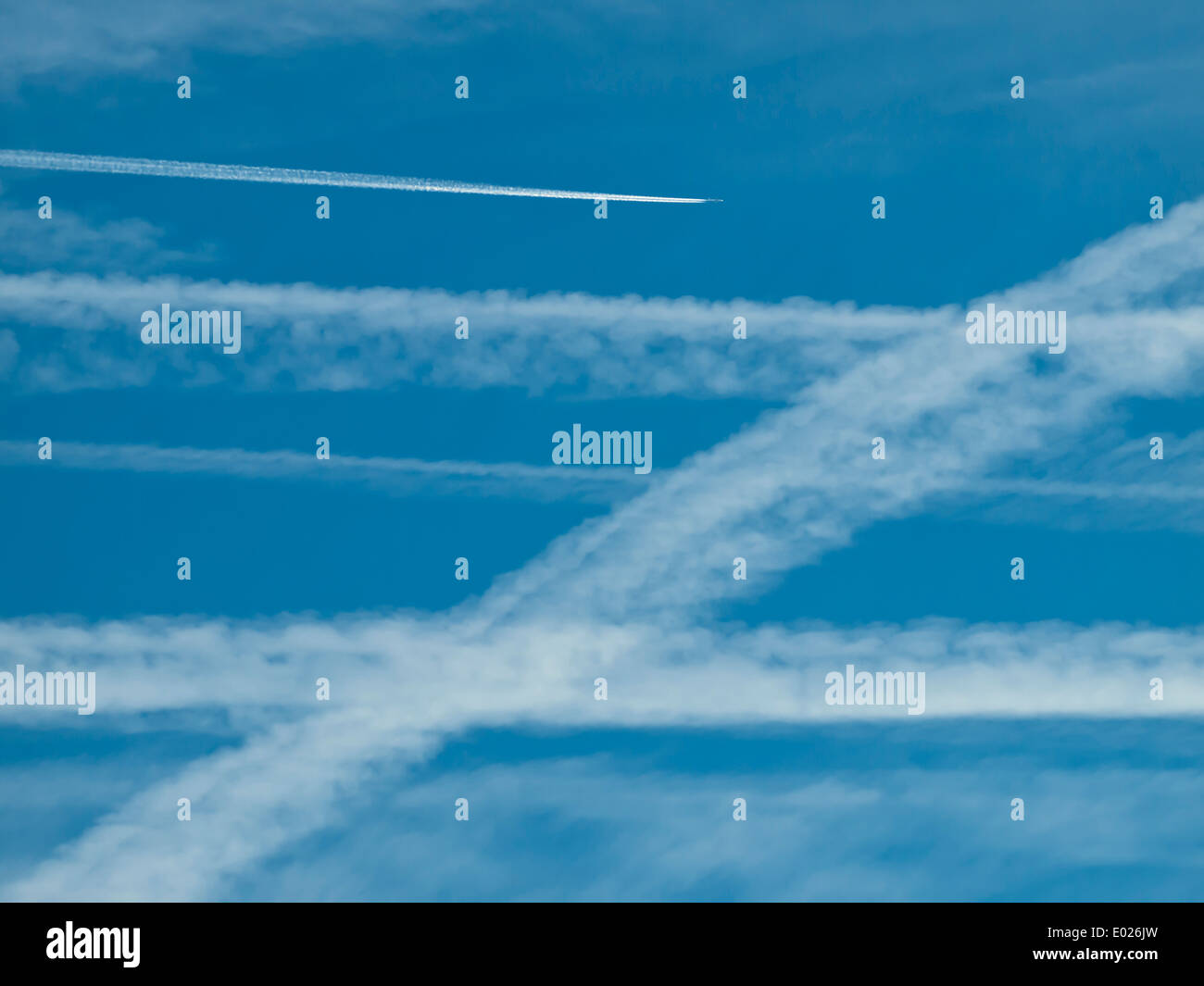 Patrón de muchas estelas de condensación/vapores estelas de aviones en el cielo azul. Foto de stock