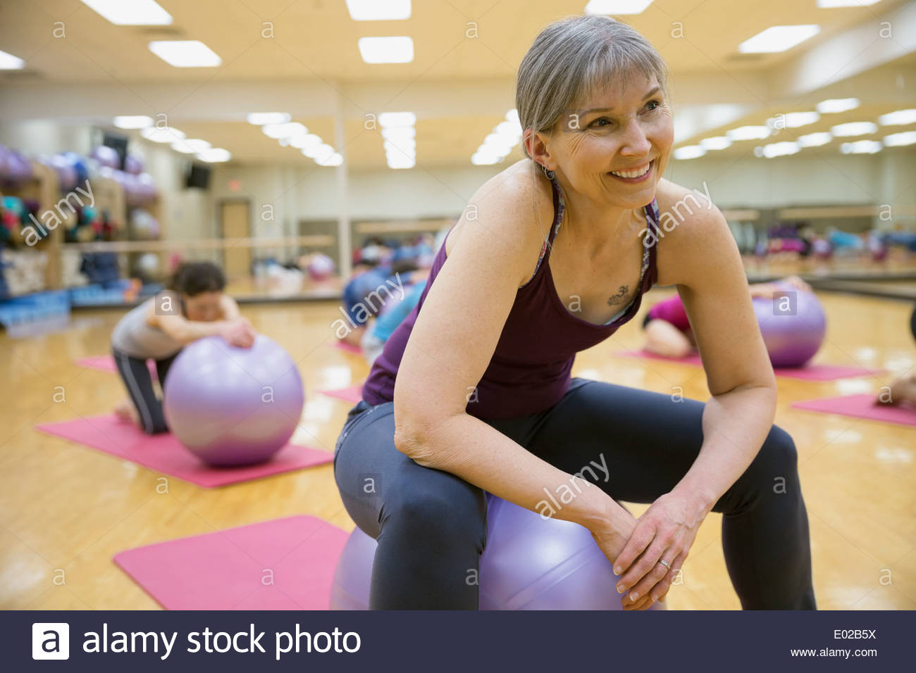 Mujer sonriente en el fitness ball en clase de ejercicios Foto de stock