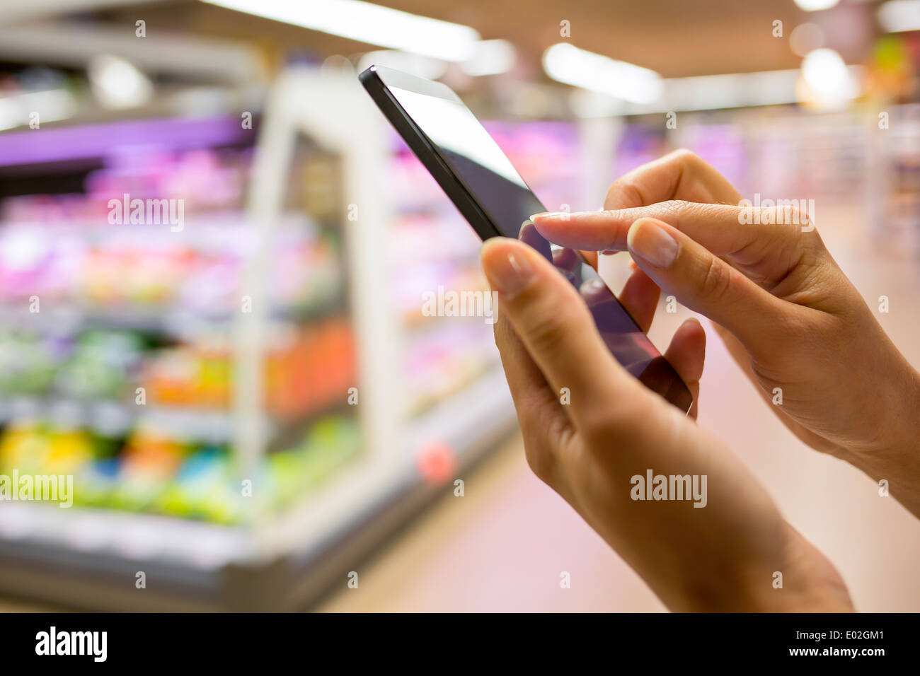 Tienda femenina cerca de teléfono celular Foto de stock