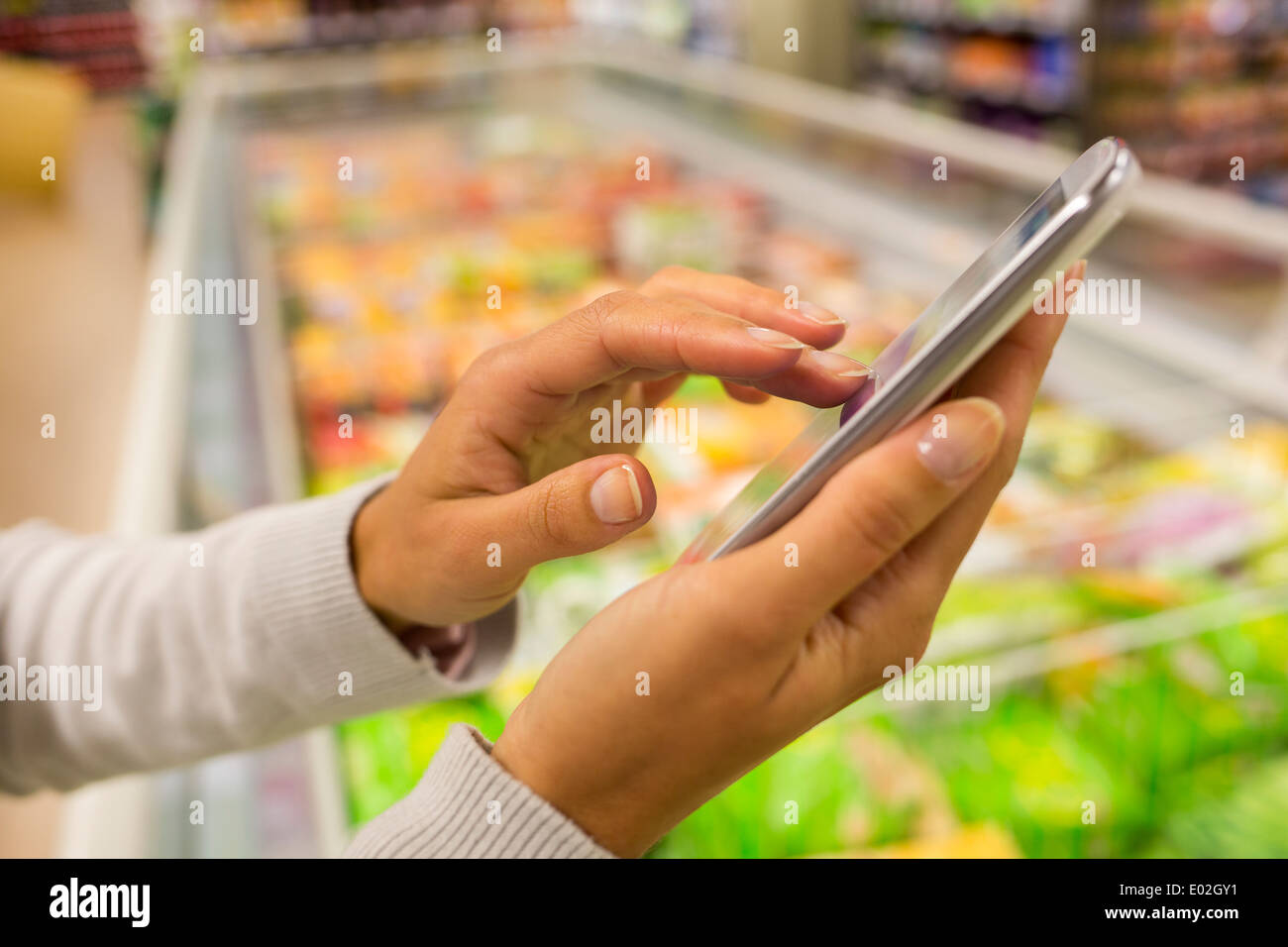 Tienda femenina cerca de teléfono celular Foto de stock