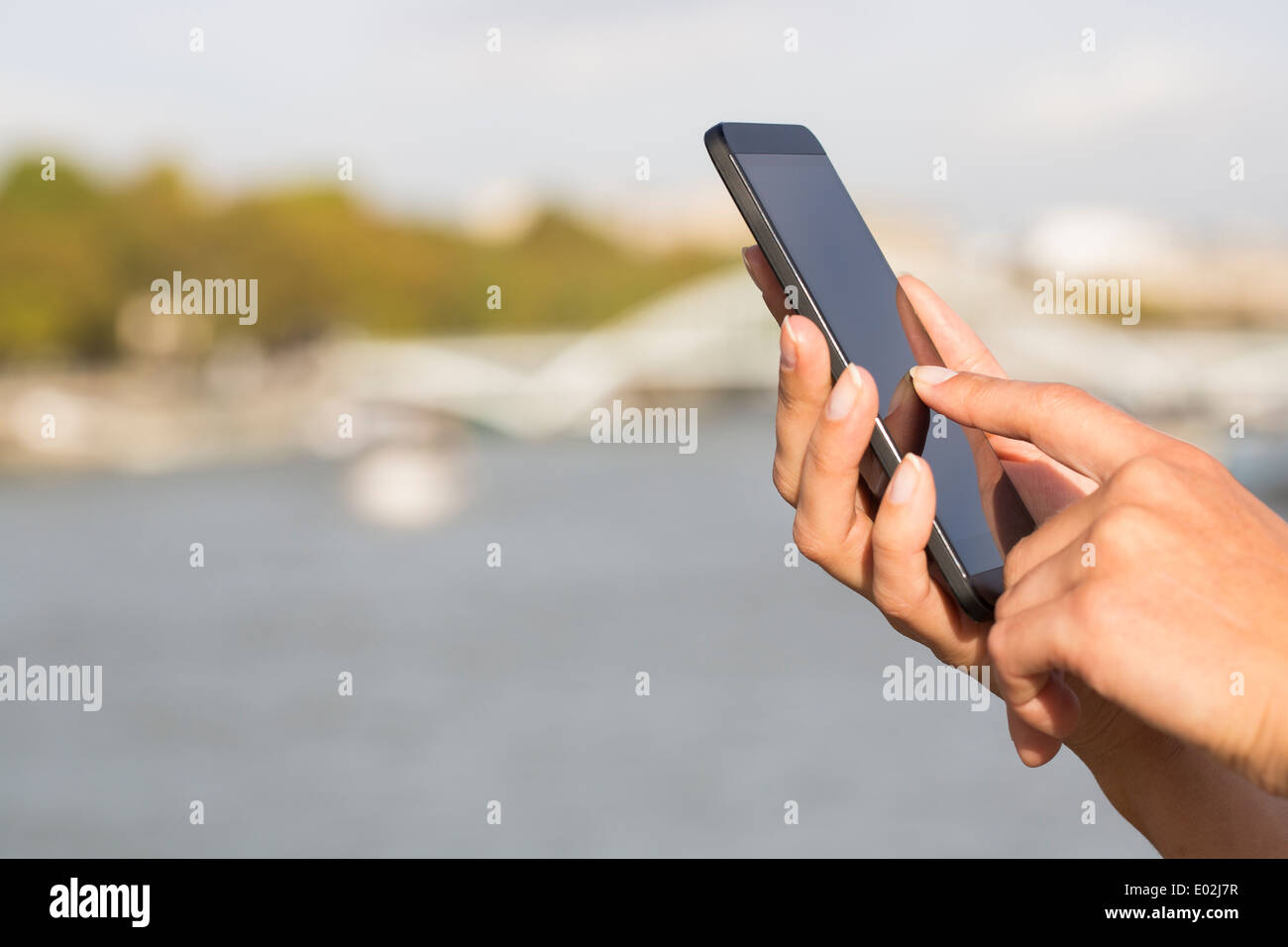 Mujeres cerca de manos teléfono móvil casa flotante sena puente mensaje sms correo electrónico Foto de stock