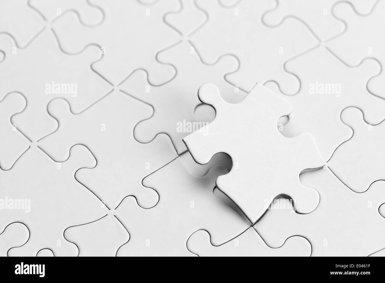 Puzzle blanco con copia espacio y la pieza del puzzle. Foto de stock