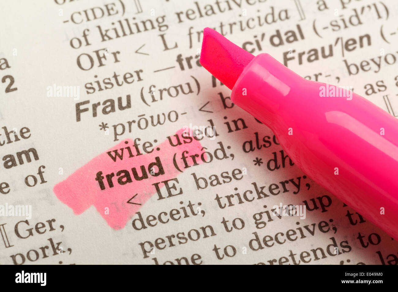 La palabra fraude resaltada en diccionario con marcador amarillo rotulador. Foto de stock