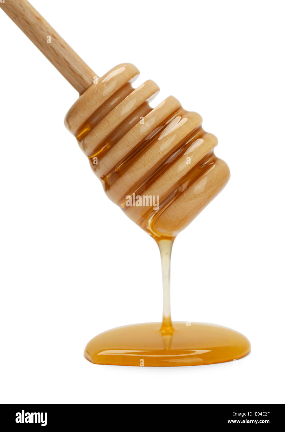 Agitar madera palo con miel goteo aislado sobre fondo blanco. Foto de stock