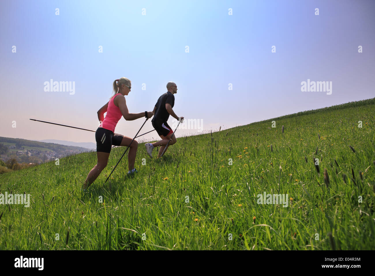 Una pareja haciendo nordic walking a través del paisaje rural de formación Foto de stock