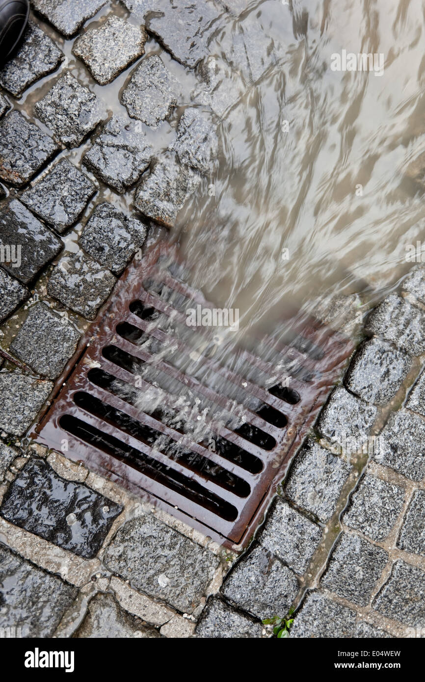 El párpado del metal de un canal para las aguas pluviales, Deckel aus Metall eines Kanals fuer Regenwasser Foto de stock