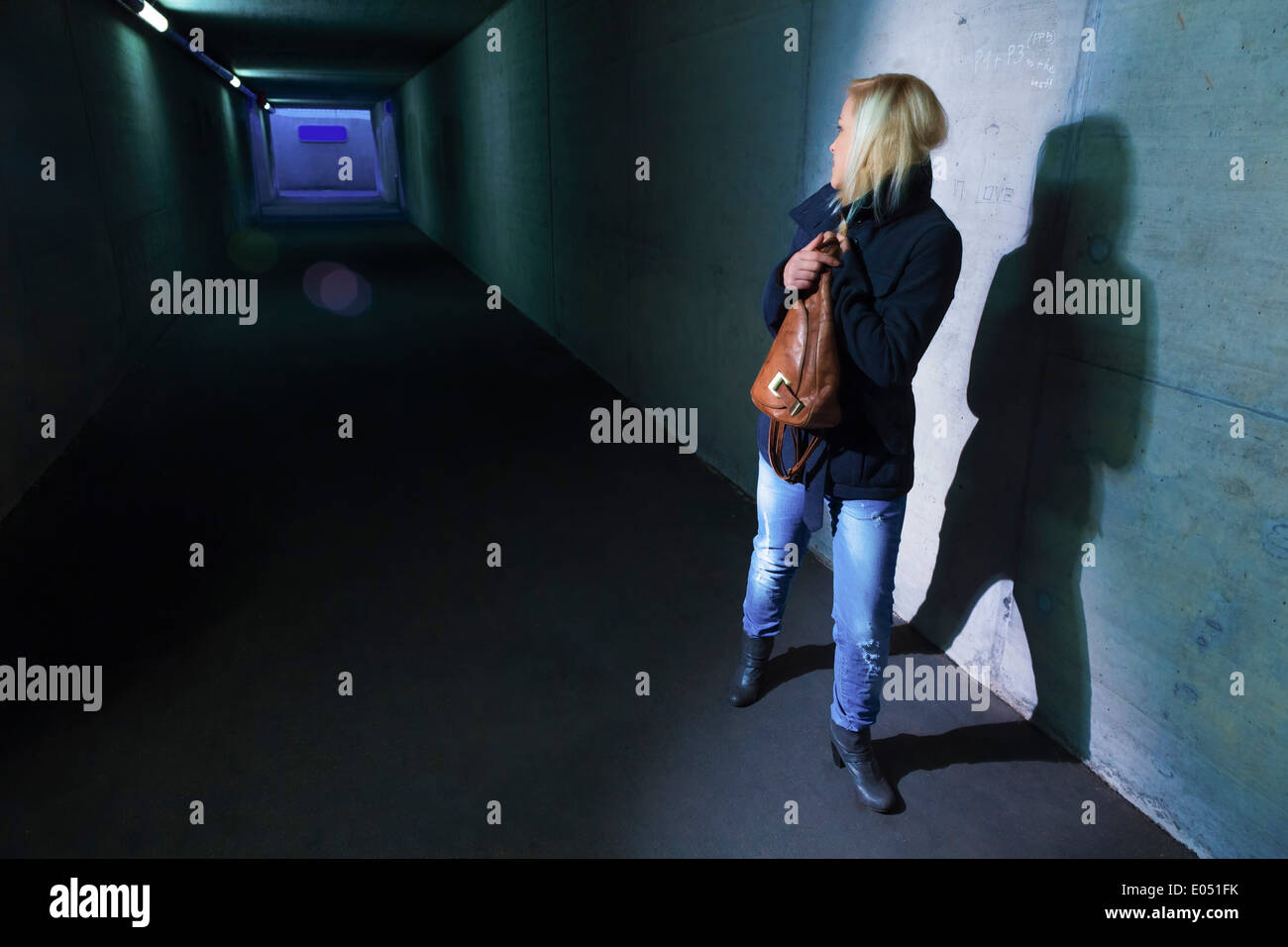 Una joven en un paso subterráneo para peatones es miedo de molestia y la actividad delictiva, Eine junge Frau en einer Unterfuehrun Foto de stock