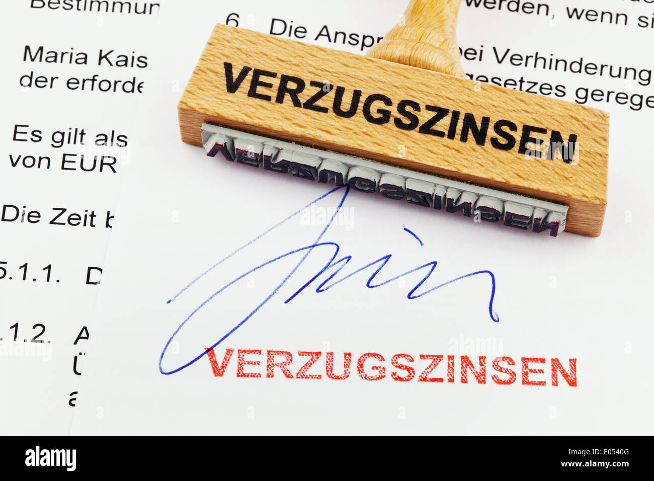 Un sello de madera se encuentra en un documento. Sello alemán: Intereses sobre las cuotas atrasadas, Ein Stempel aus Holz liegt auf einem Dokument. Deutsche Foto de stock