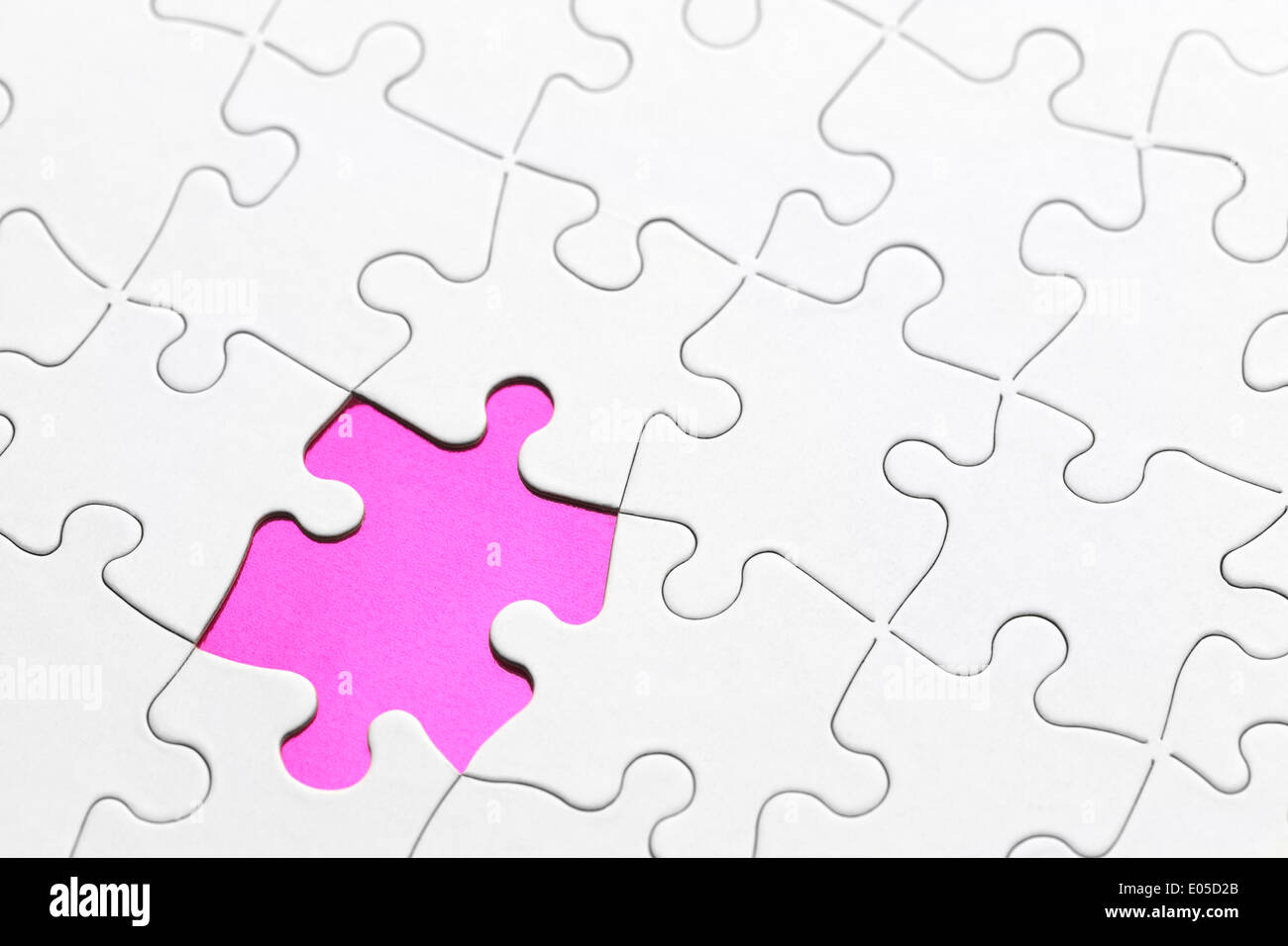 Puzzle en blanco con la pieza faltante en rosa. Foto de stock