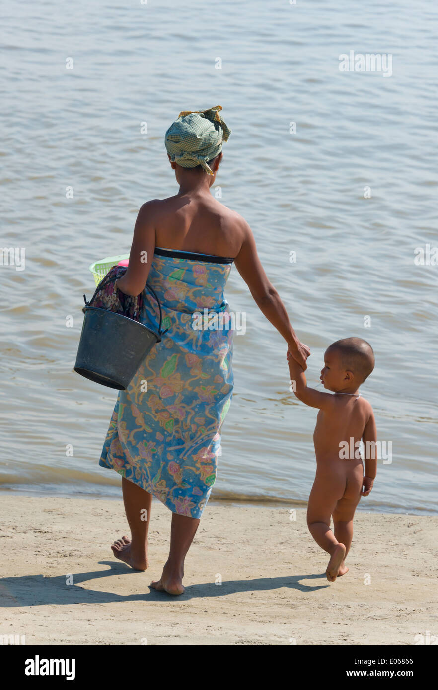 Mujer con niño en la playa del río Ayarwaddy, Mingun, Myanmar Foto de stock