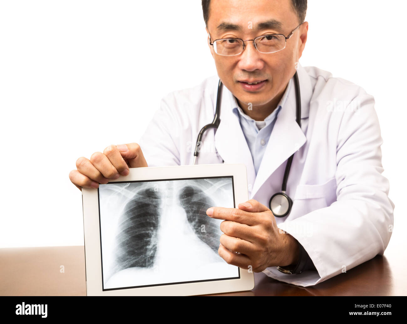 Médico varón mostrando una imagen de rayos X digitales en un tablet Foto de stock