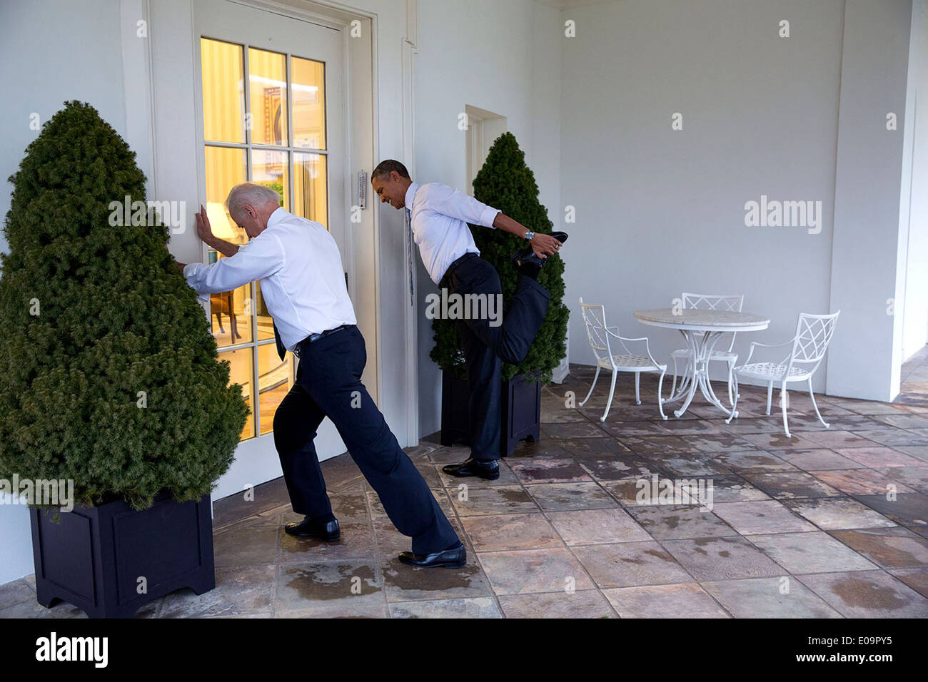 El presidente estadounidense Barack Obama y el vicepresidente Joe Biden estira participan en "Let's Move!' de vídeo grabar en la columnata de la Casa Blanca el 21 de febrero de 2014 en Washington, DC. Foto de stock