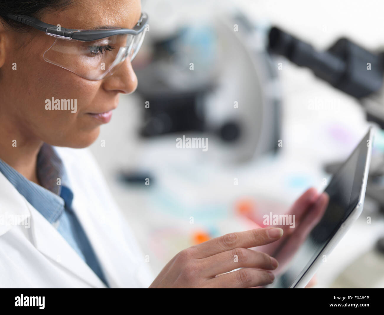 Investigadora ver resultados de pruebas en una tableta digital en el laboratorio Foto de stock