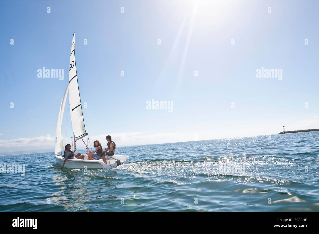 Tres jóvenes amigos navegando desde puerto Foto de stock