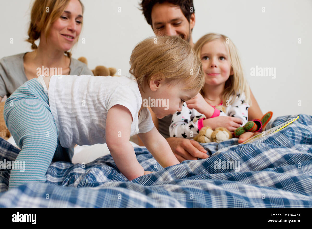 Bebé de Un año de edad chica arrastrándose en la cama de los padres. Foto de stock