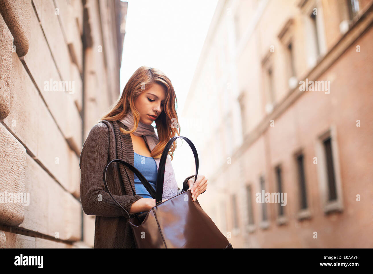 Mujer joven busca ansiosamente su bolsa de hombro Foto de stock