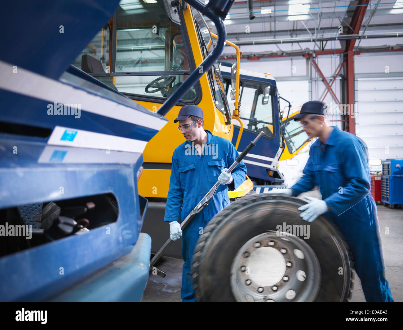 Los ingenieros se preparan para fijar la rueda en la fábrica de reparación de camiones Foto de stock