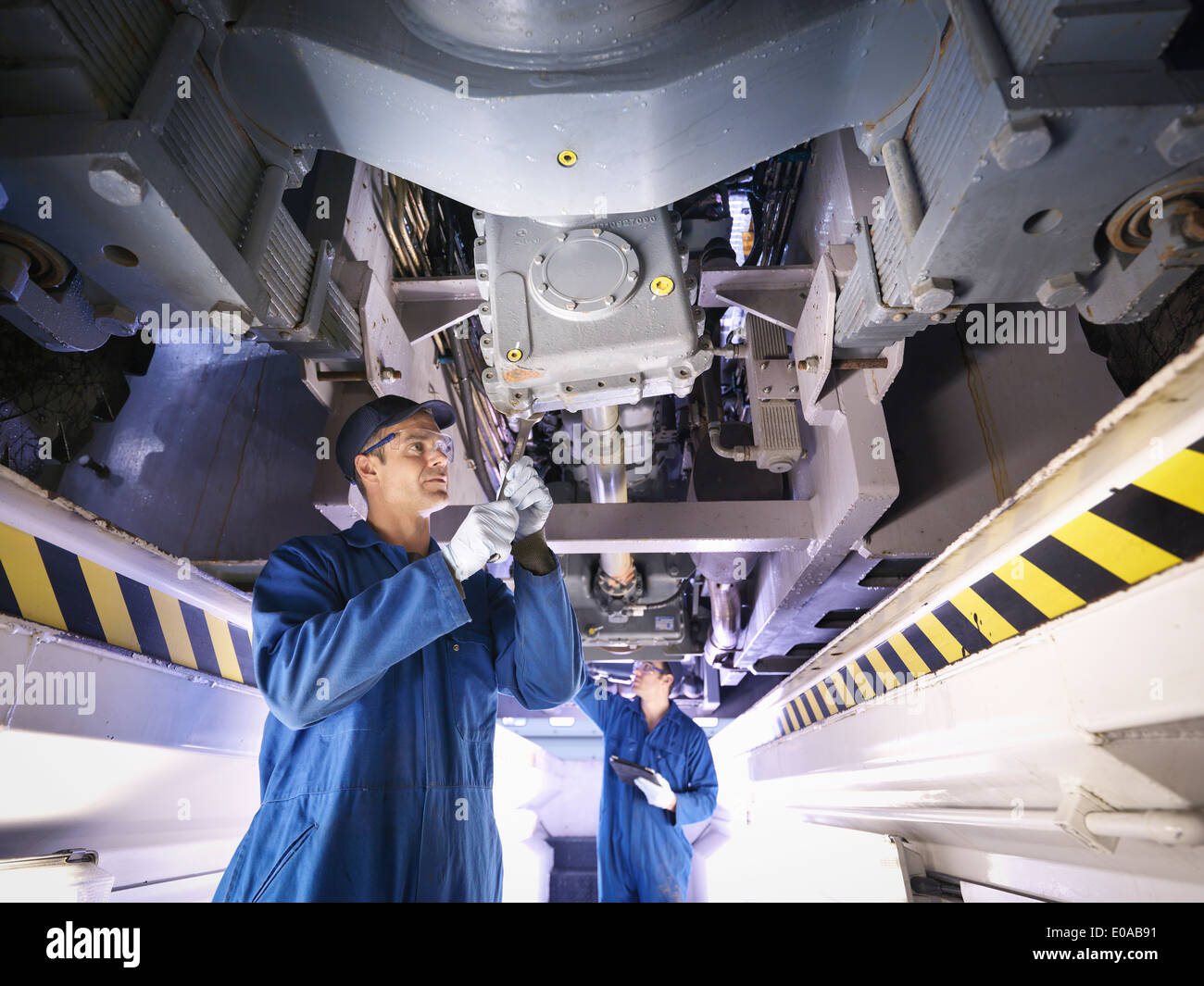 Los ingenieros de la fábrica de reparación de camiones debajo Foto de stock