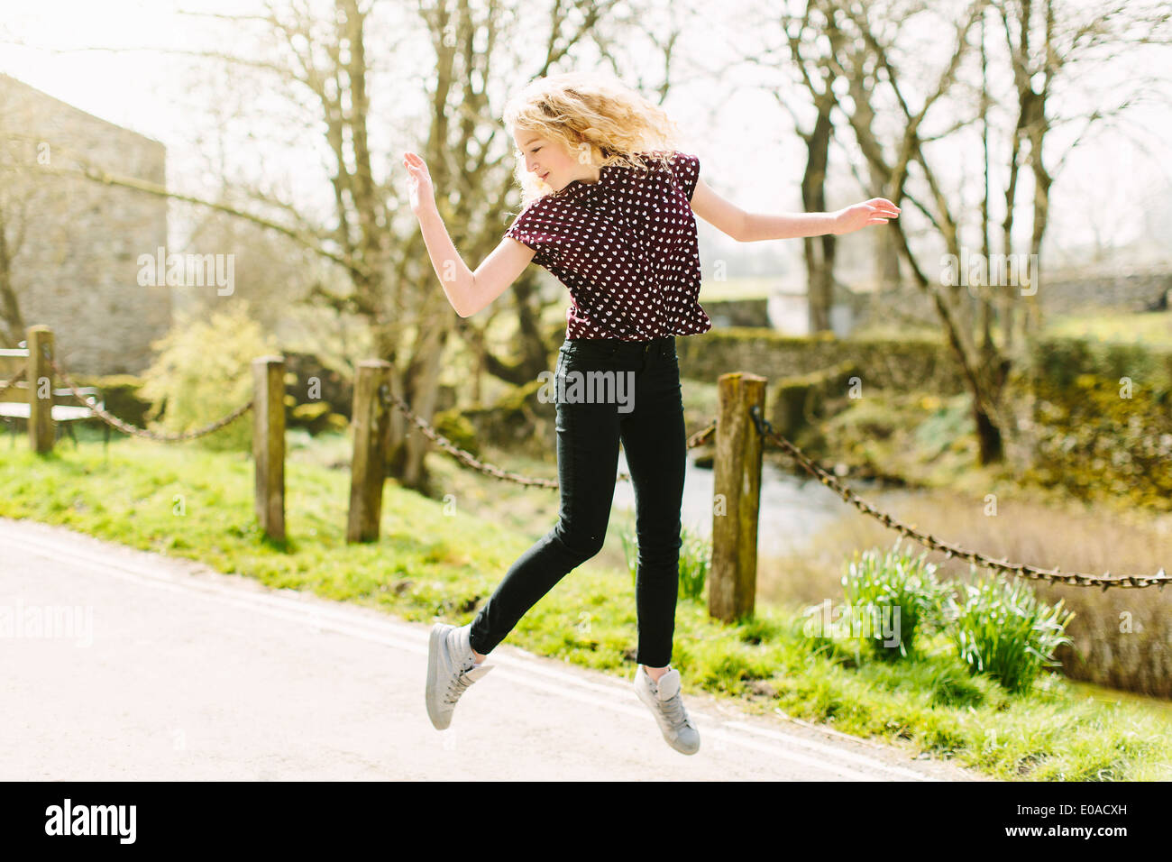 Adolescente Saltando sobre caminos rurales de aire. Foto de stock