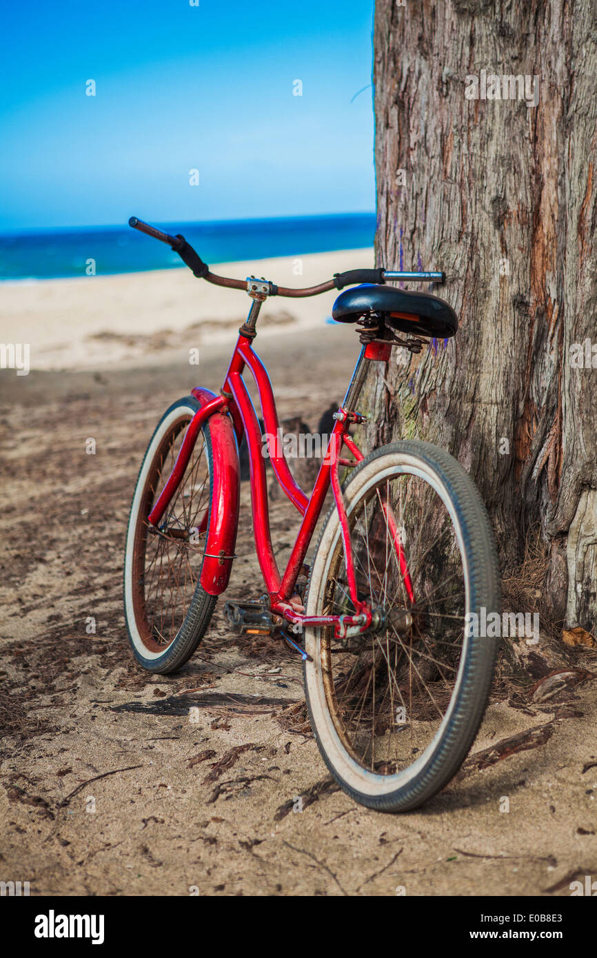 Bicicleta roja estacionada en playa, Kaua'i, Hawaii, EE.UU. Foto de stock