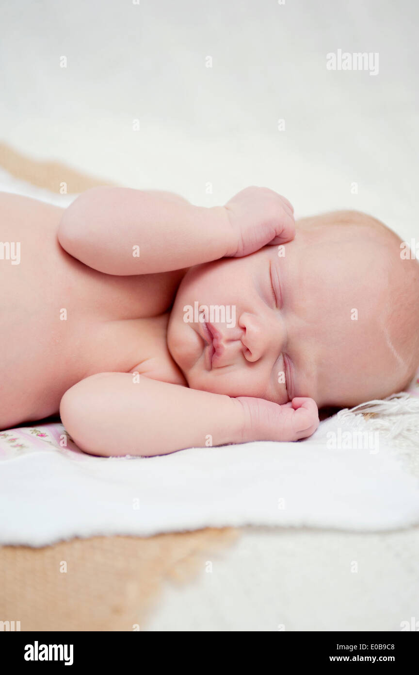 Bebé dormido con las manos junto a cara Foto de stock
