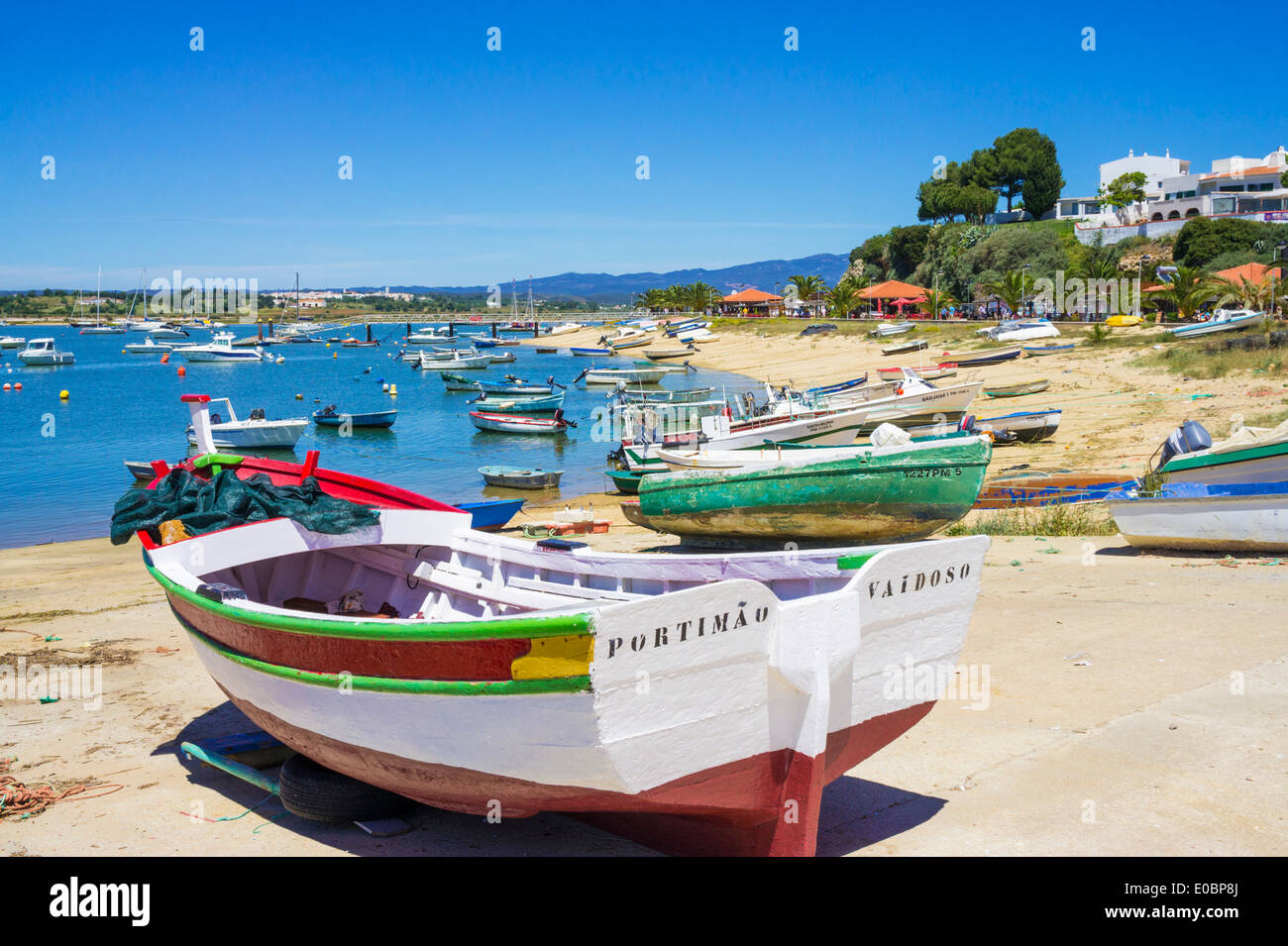 Pintado tradicionales barcos pesqueros amarrados a lo largo del paseo marítimo, en la aldea de Alvor Algarve Portugal Europa UE Foto de stock