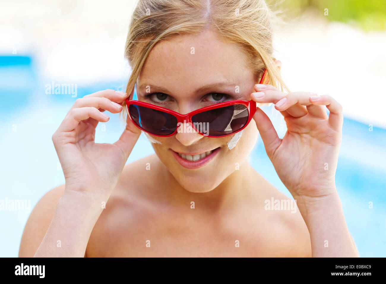 Mujer joven en verano con gafas de sol y crema de los Suns, Junge Frau Im Sommer mit Sonnenbrille und Sonnen Creme Foto de stock