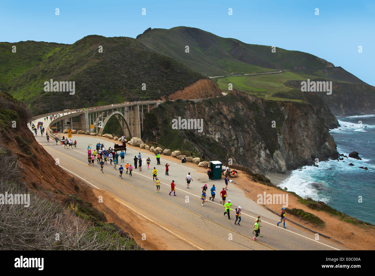 Los corredores cross Bixby Puente en la autopista 1, que es el punto medio del recorrido del Maratón 2014 Big Sur - BIG SUR, CALIFORNIA Foto de stock