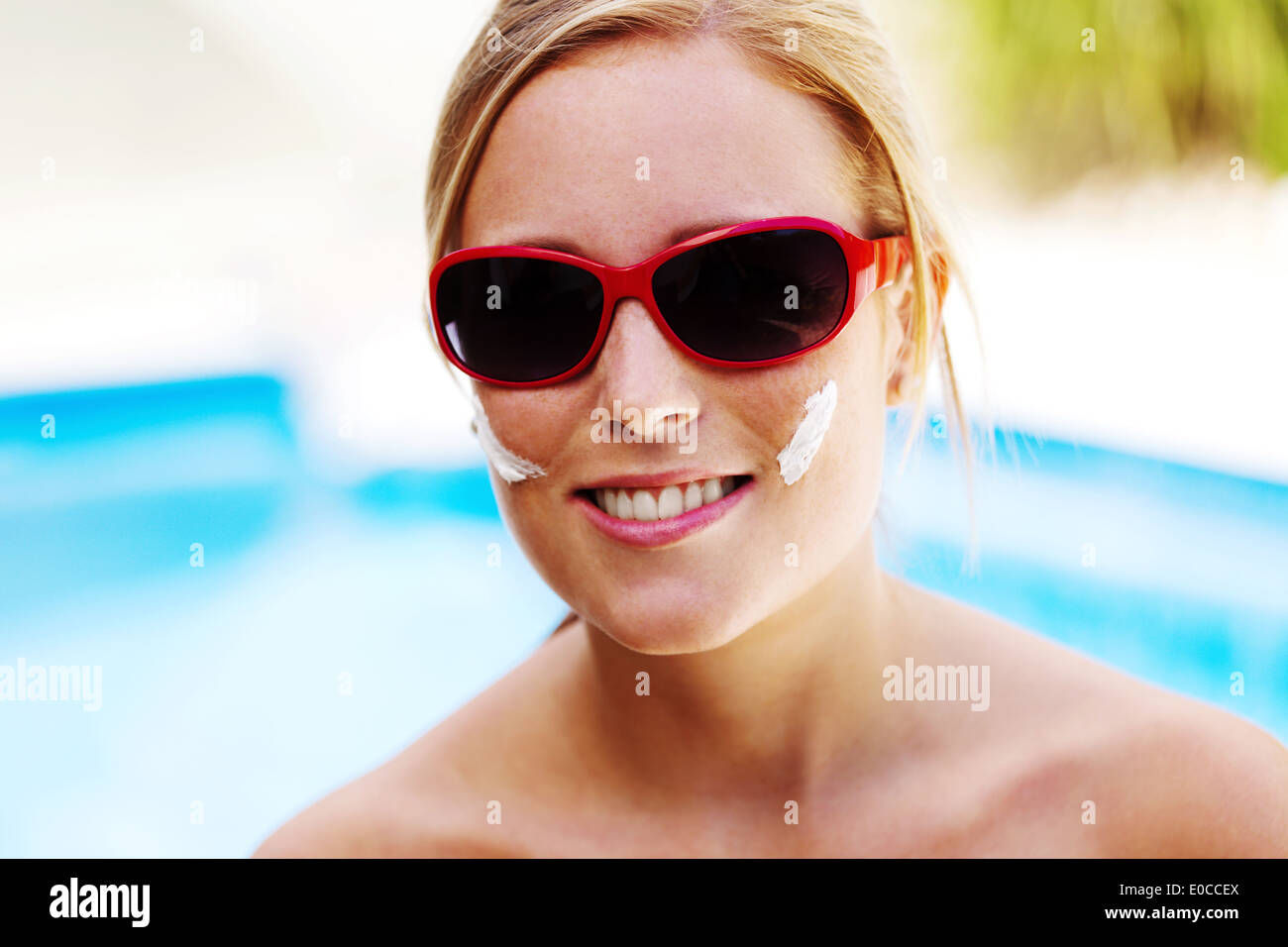 Mujer joven en verano con gafas de sol y crema de los Suns, Junge Frau Im Sommer mit Sonnenbrille und Sonnen Creme Foto de stock