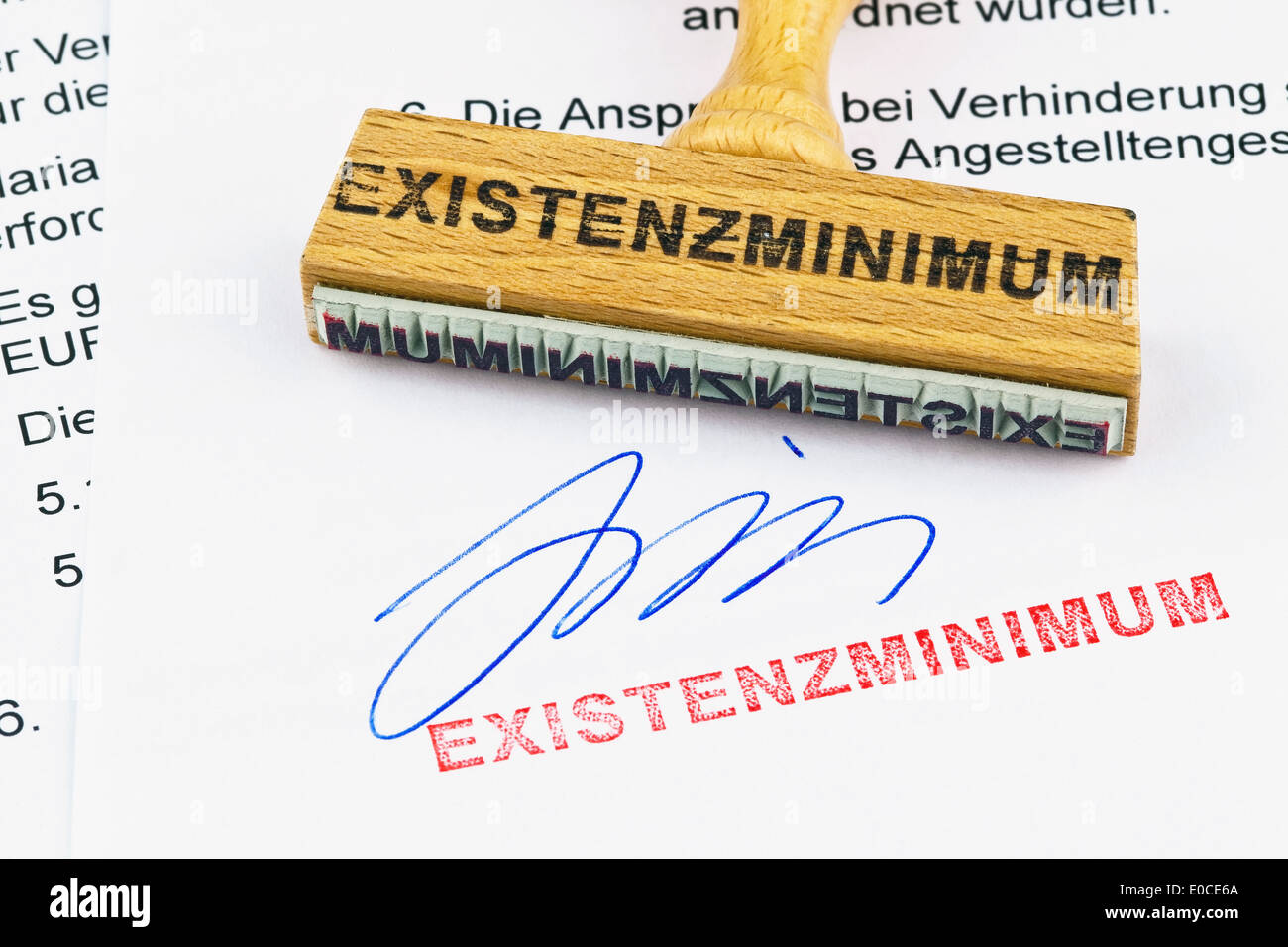 Un sello de madera se encuentra en un documento. Etiqueta de nivel de subsistencia, Ein Stempel aus Holz liegt auf einem Dokument. Aufschrift Existenzm Foto de stock