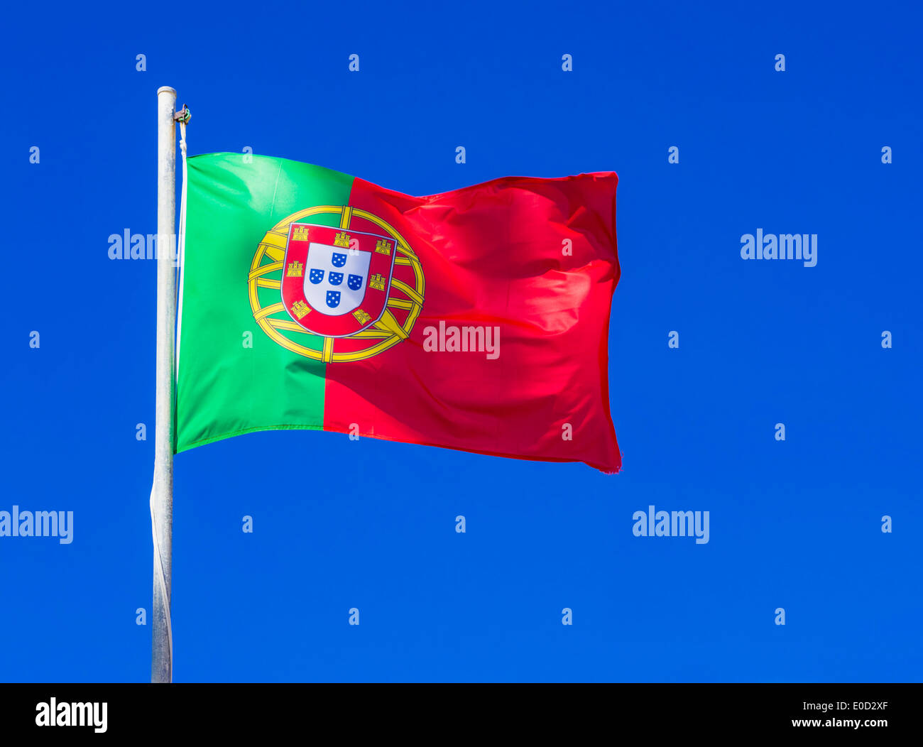 Bandera portuguesa contra un fondo de cielo azul claro Foto de stock