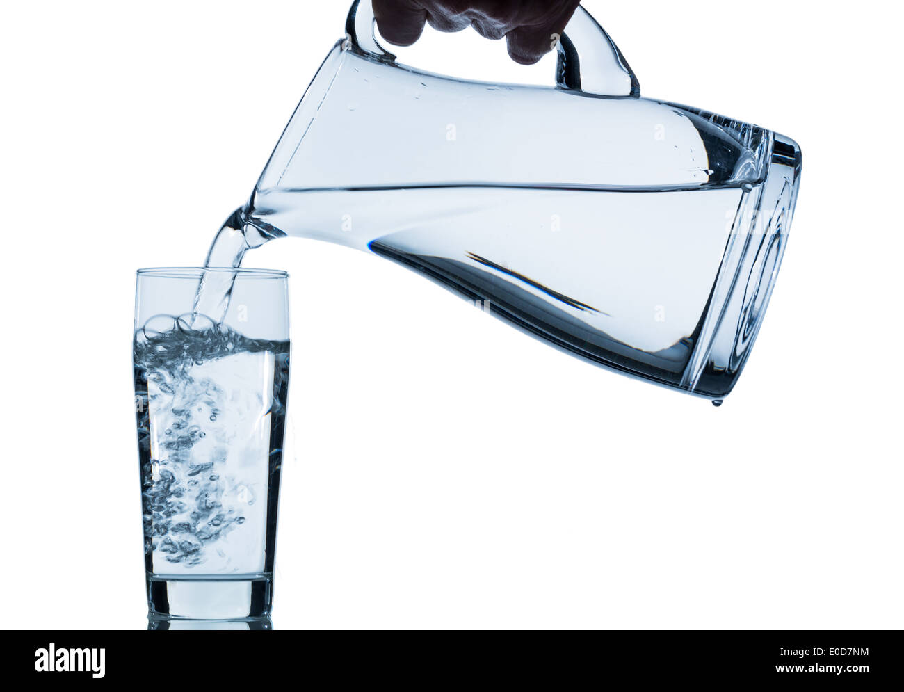 El agua pura se convierte en un vaso de agua de una jarra eingeleert. Agua potable fresca, Reines Wasser wird en ein Wasserglas Aus einem Foto de stock