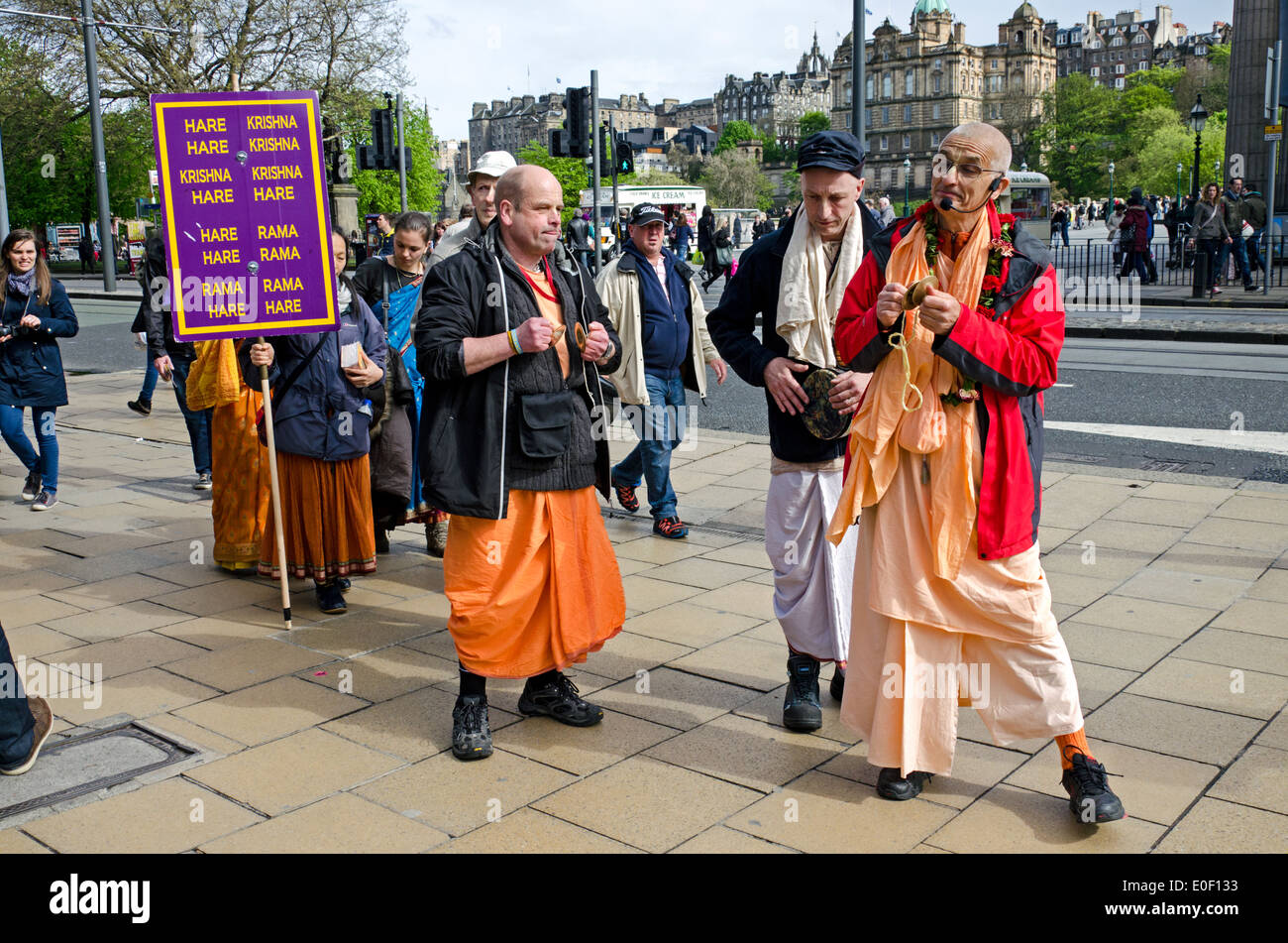 Los miembros del Movimiento Hare Krishna cantan como ellos hacen su camino a lo largo de la calle Princes Street en Edimburgo, Escocia, Reino Unido. Foto de stock